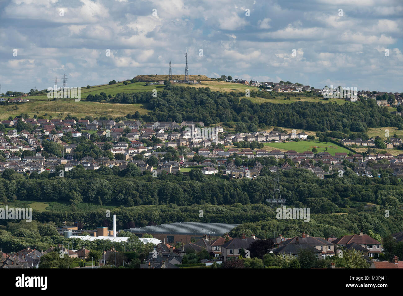 Hillside suburban area with housing, green fields, woodland & transmitters  on sunny day - Shipley & Wrose areas of Bradford, West Yorkshire, GB, UK. Stock Photo