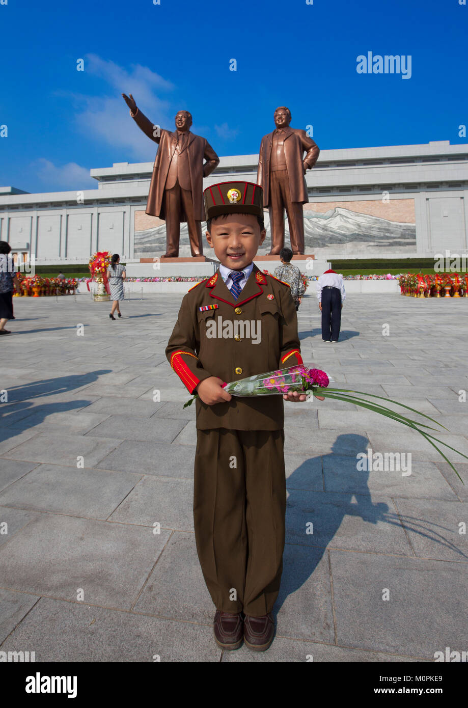 North Korean boy in army uniform paying respect to the two statues of the Dear Leaders in Grand monument of Mansu hill, Pyongan Province, Pyongyang, North Korea Stock Photo