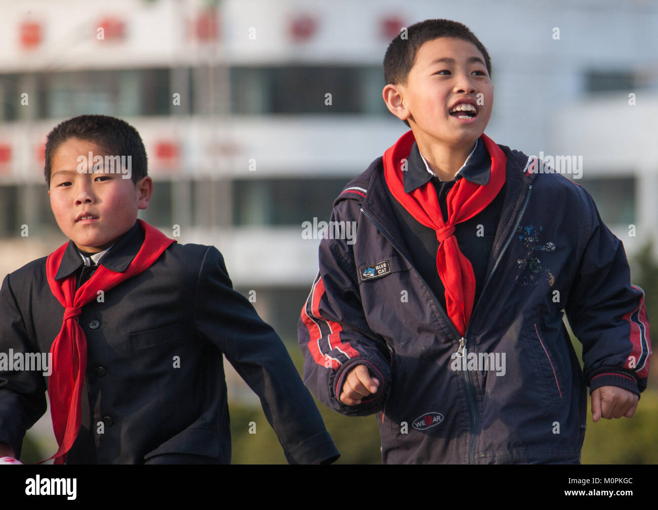 North Korean pioneer boys running in the street, Pyongan Province, Pyongyang, North Korea Stock Photo