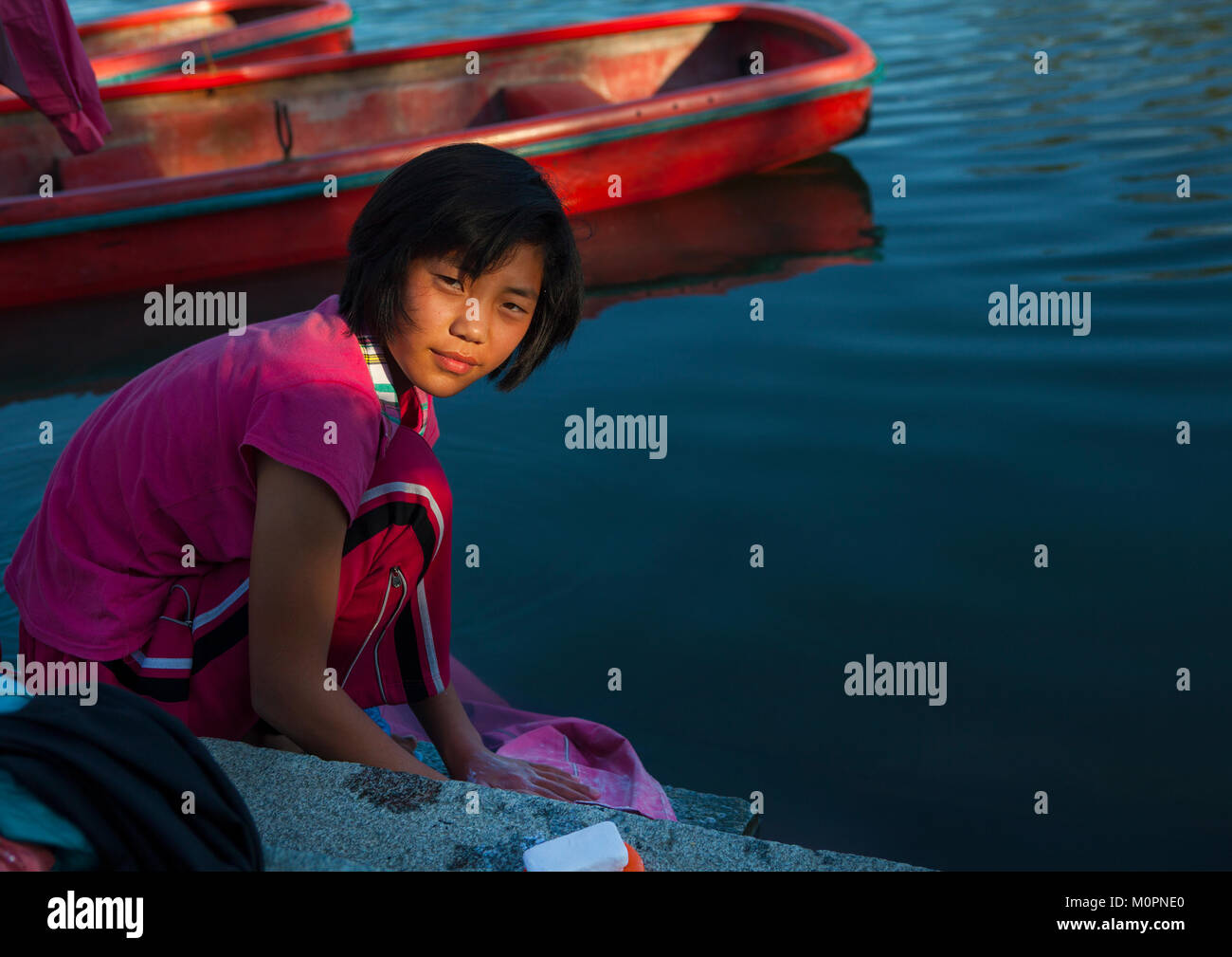 North Korean girl washing her clothes in the lake of the Songdowon