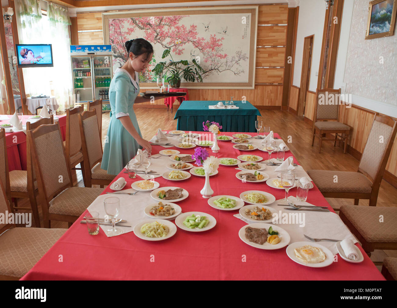 North Korean woman setting a table in a restaurant for tourists, South Hamgyong Province, Hamhung, North Korea Stock Photo