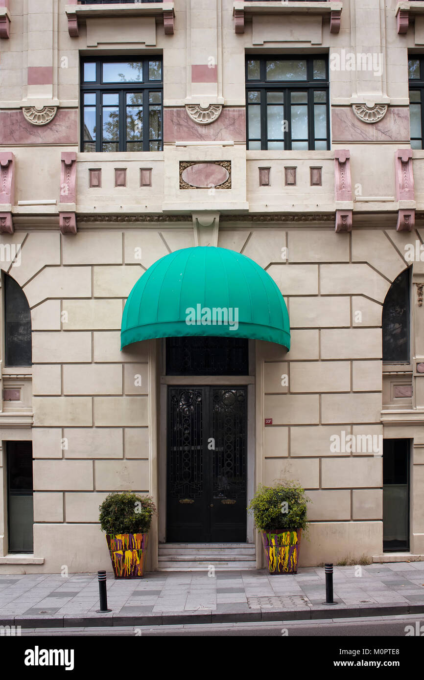 View of old building's entrance with green awning. Stock Photo