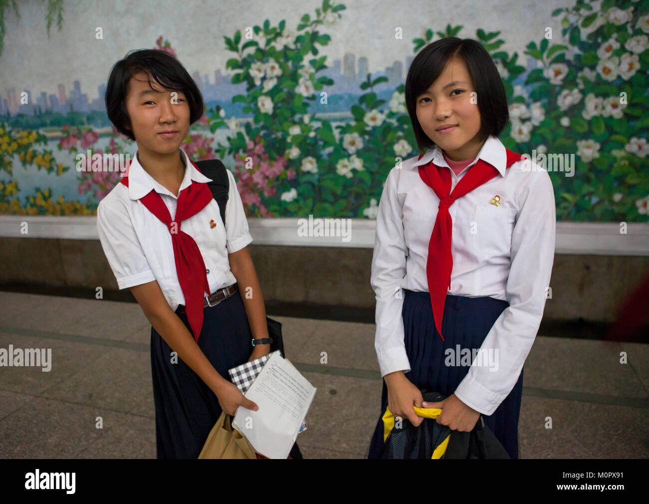 Two young pioneers girls in the subway, Pyongan Province, Pyongyang, North Korea Stock Photo