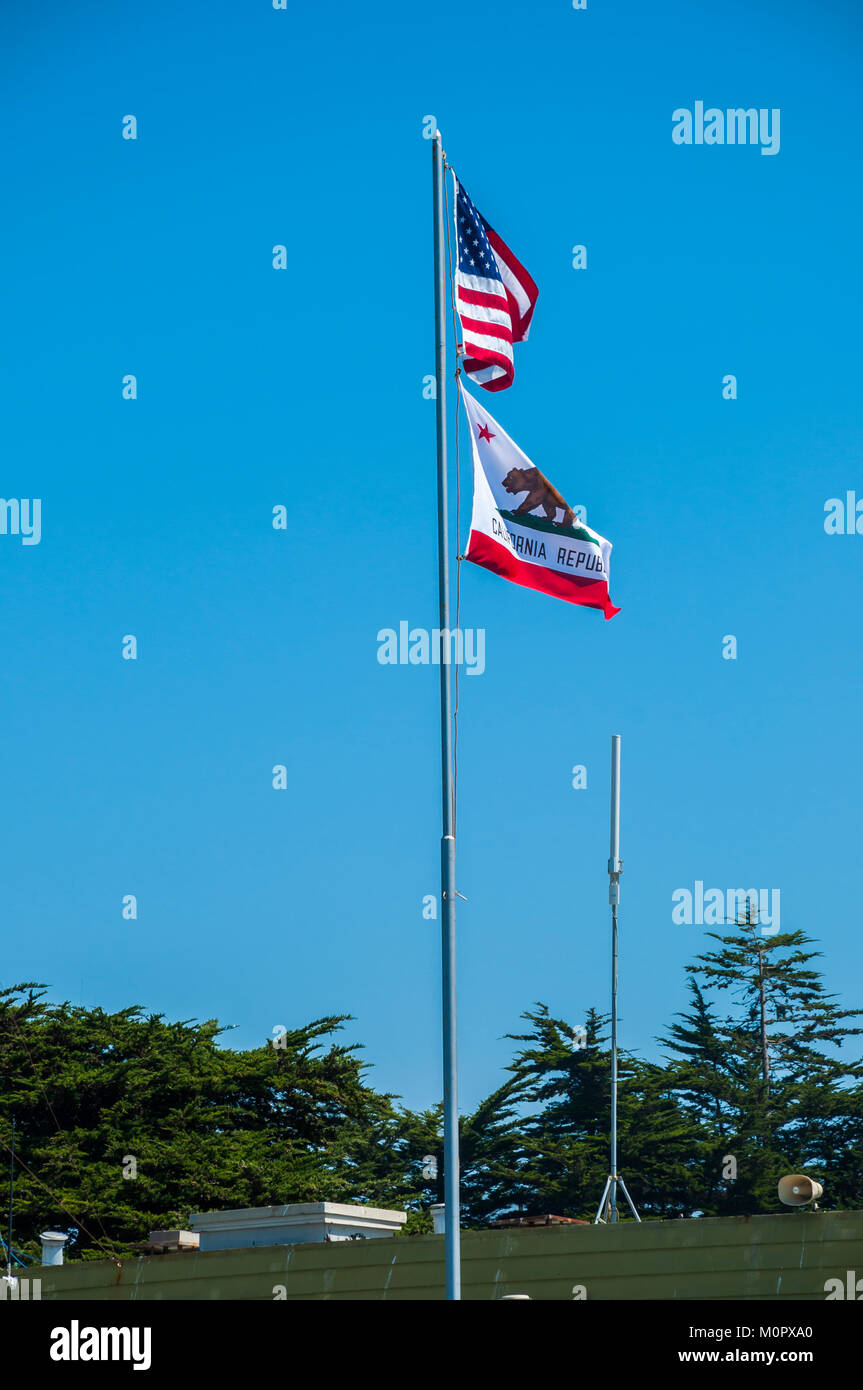The flags of USA and California waving in the wind against a bright blue sky Stock Photo
