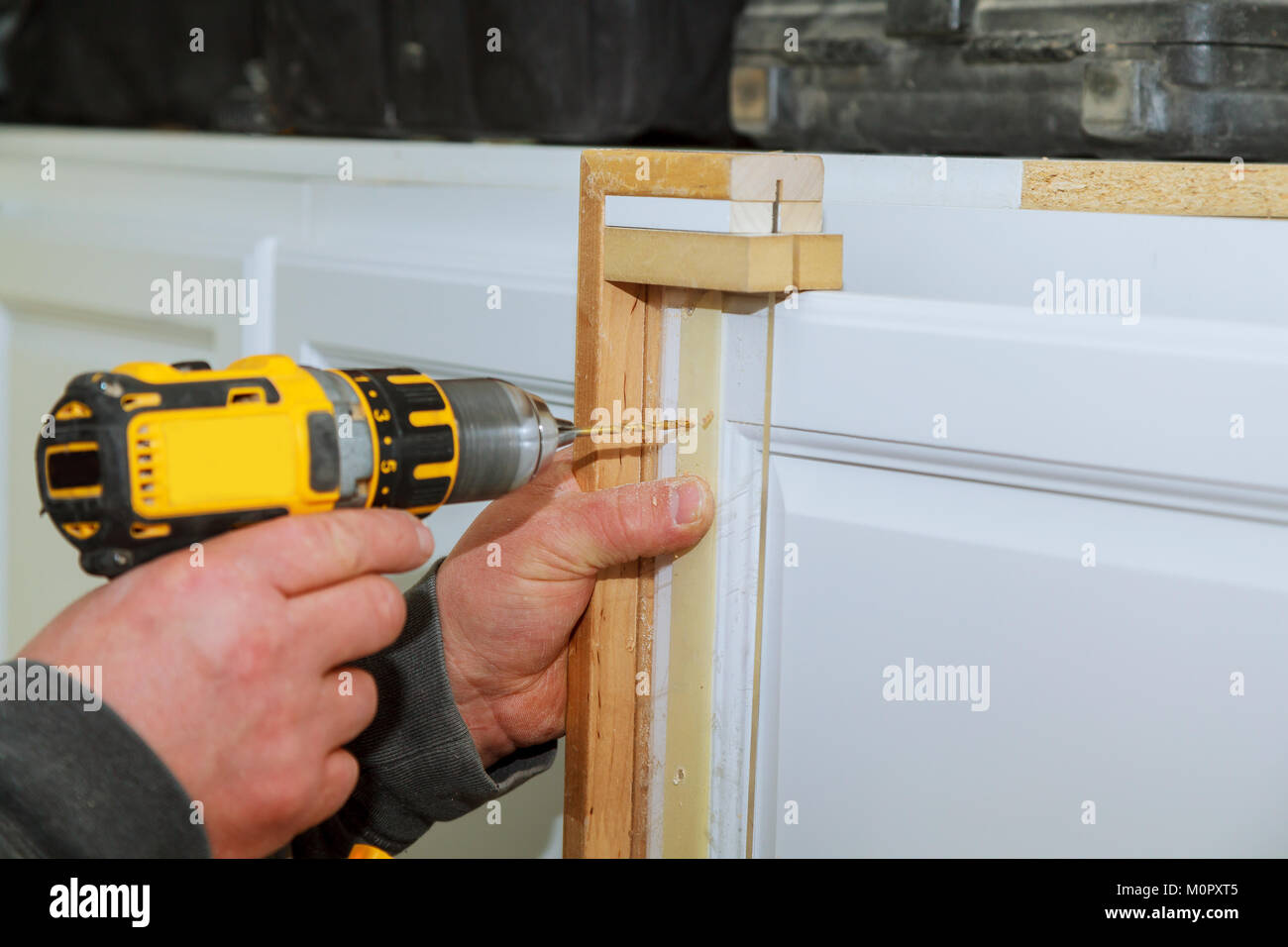 Installation of furniture hinges on the door master drills the