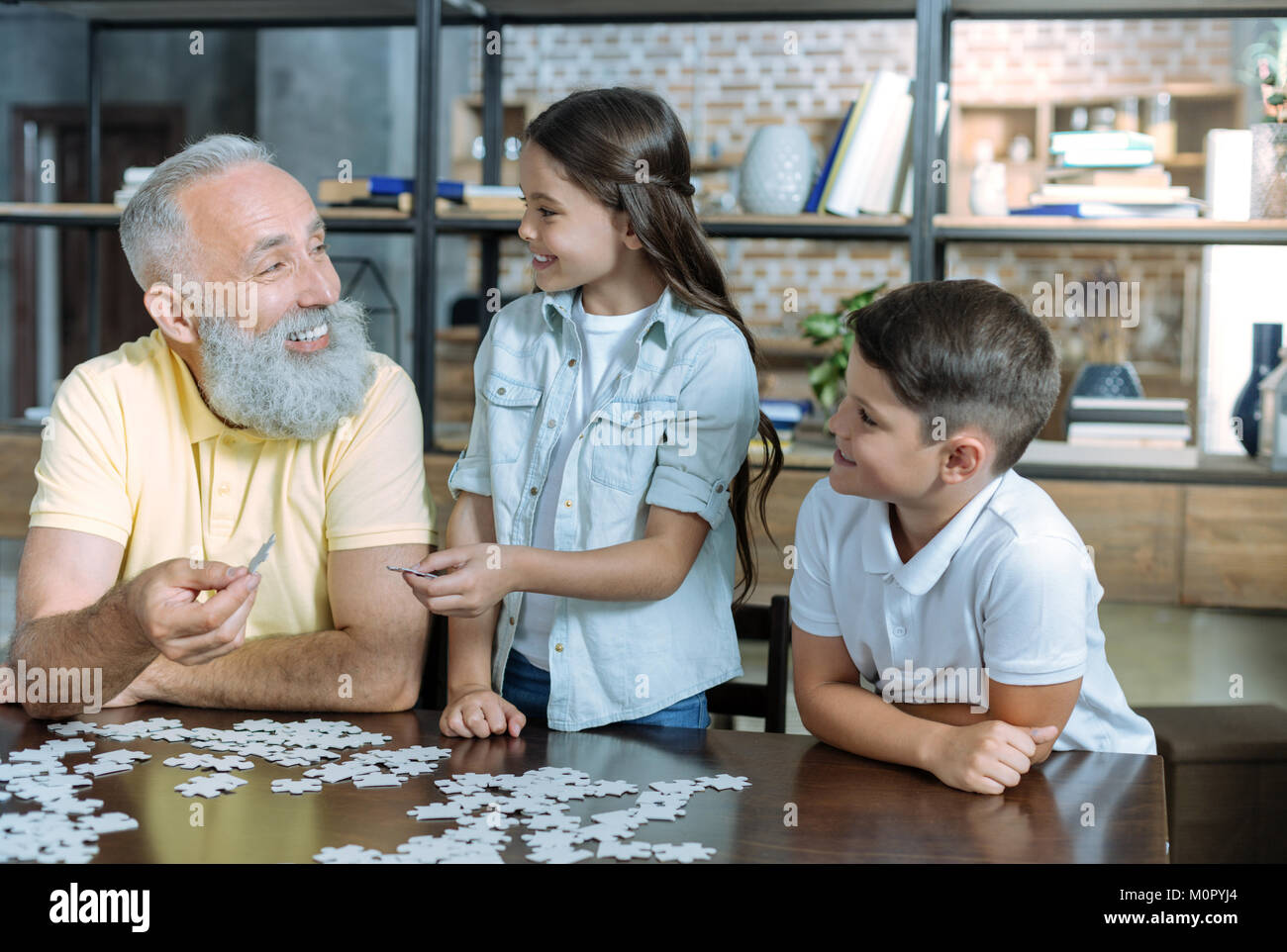 Adorable family enjoying puzzle game together Stock Photo