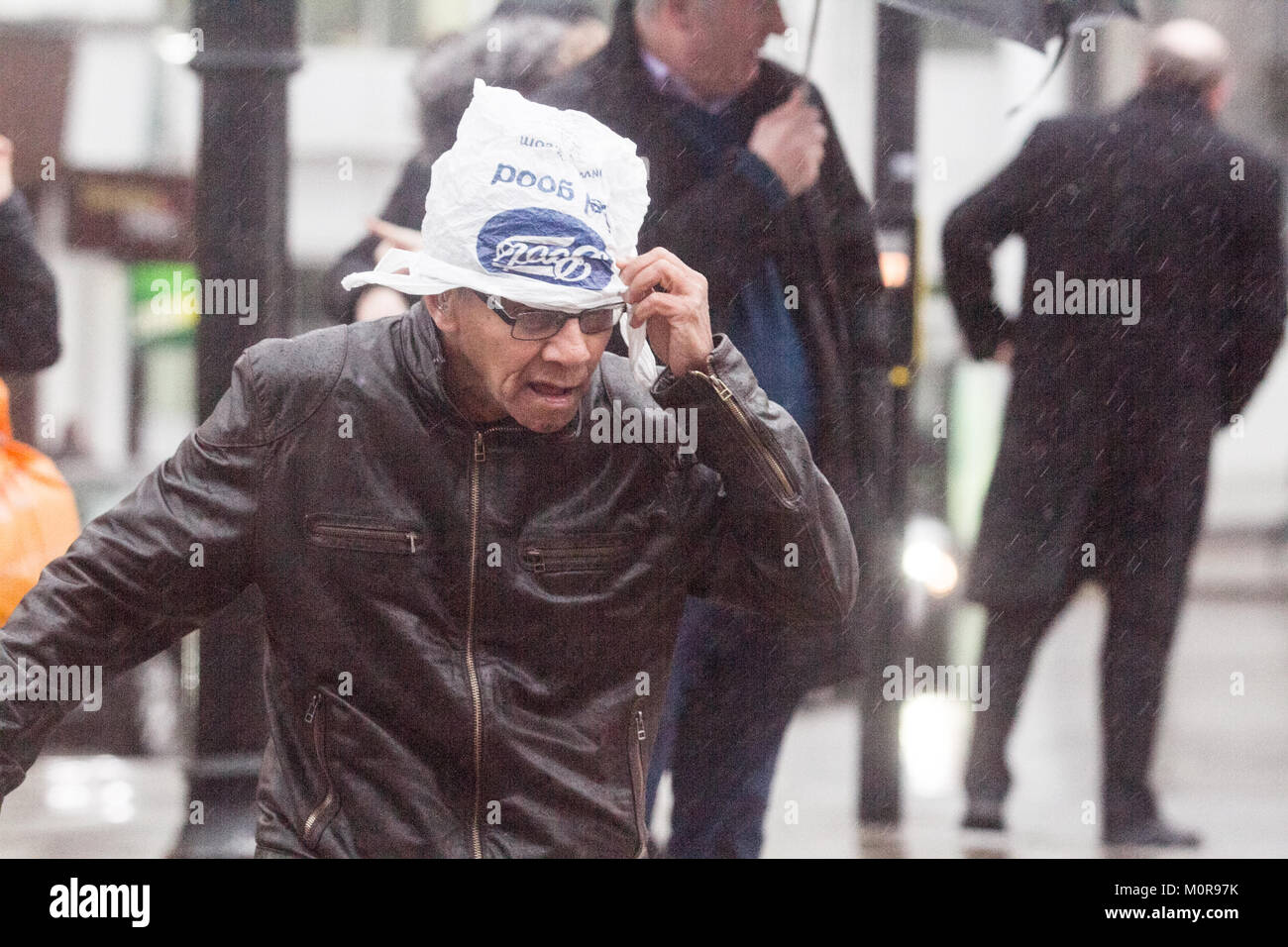 London UK. 24th January 2018. Pedestrians and shoppers are caught in heavy downpours and freezing rain in Wimbledon town centre brought about by Storm Georgina Credit: amer ghazzal/Alamy Live News Stock Photo