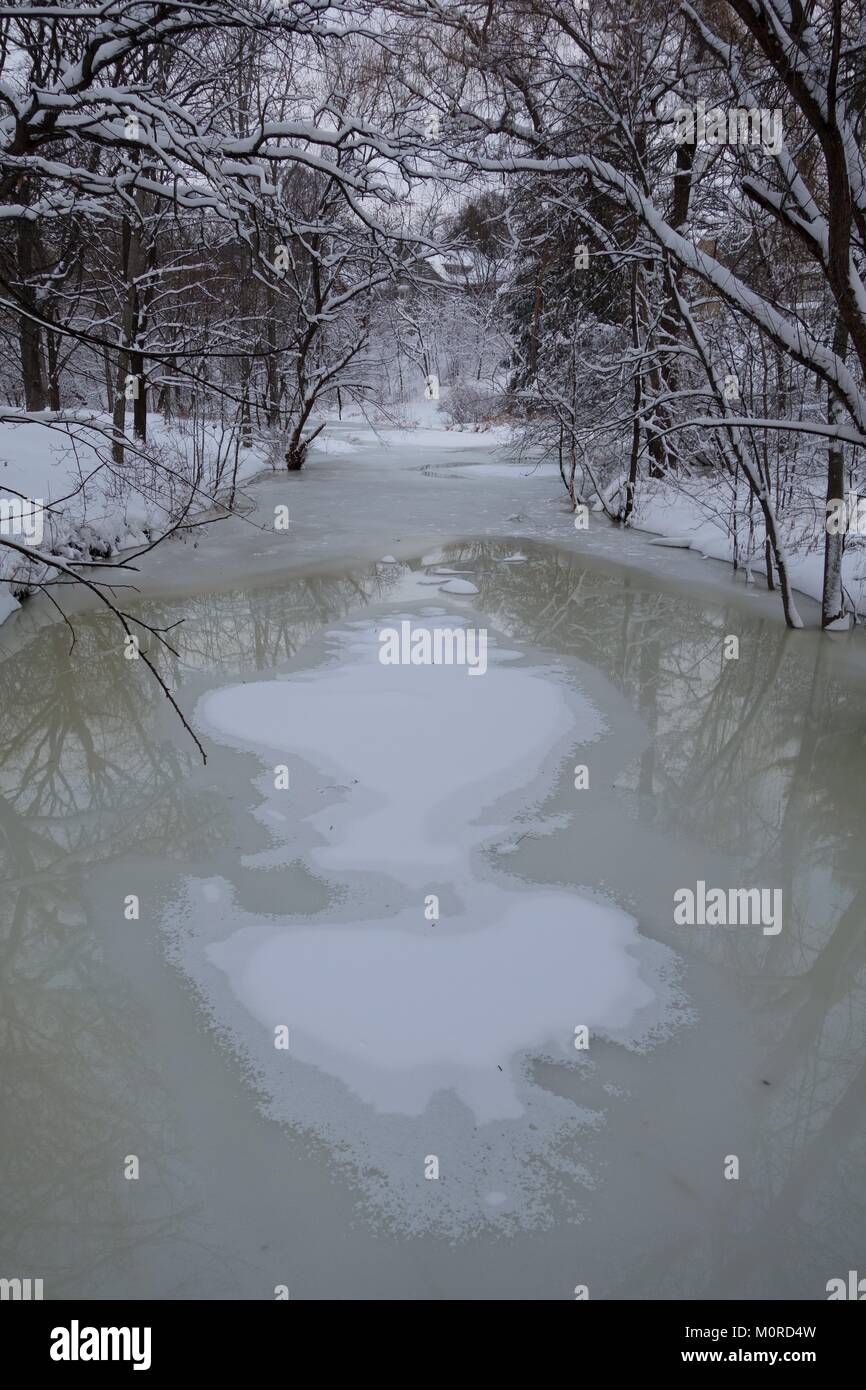 Snow creates an abstract pattern on the surface of Minnehaha Creek in Minneapolis, Minnesota, USA. Stock Photo