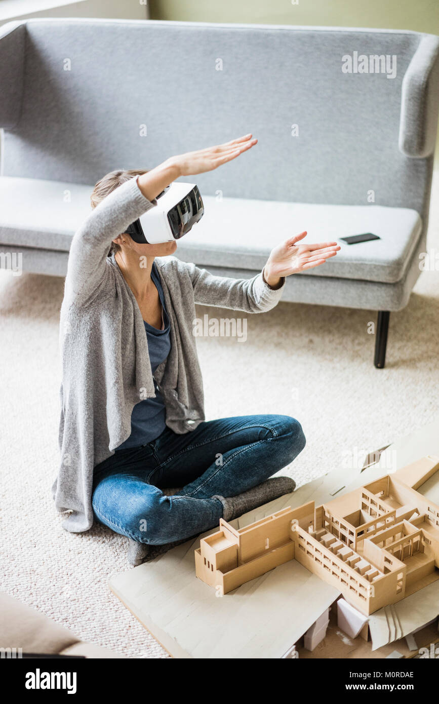 Woman in office with architectural model wearing VR glasses Stock Photo