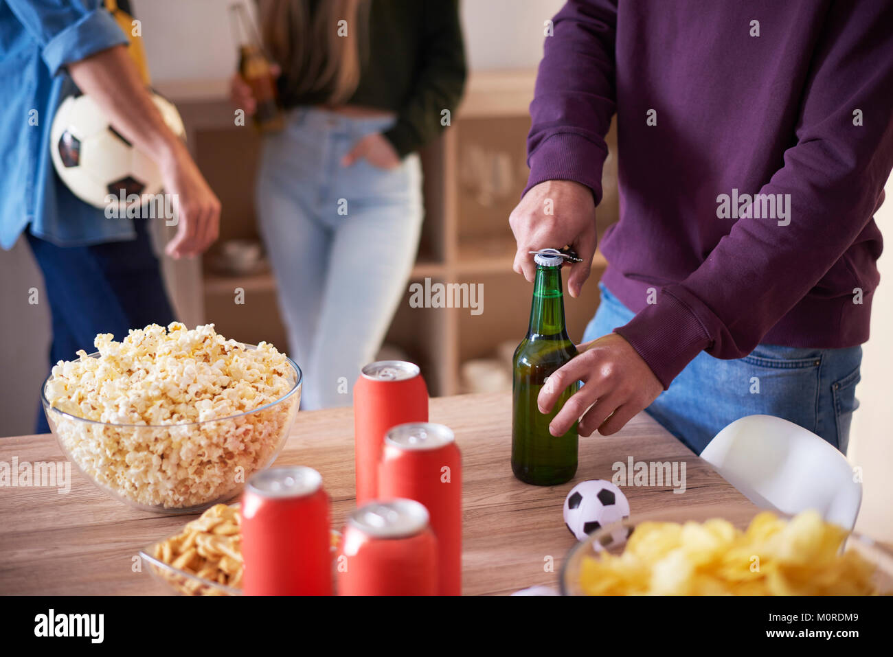 Football fan opening a bottle of beer Stock Photo