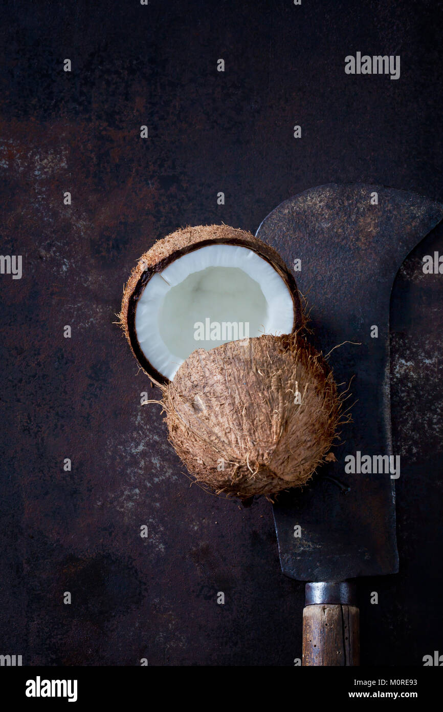 Opened coconut and old cleaver Stock Photo