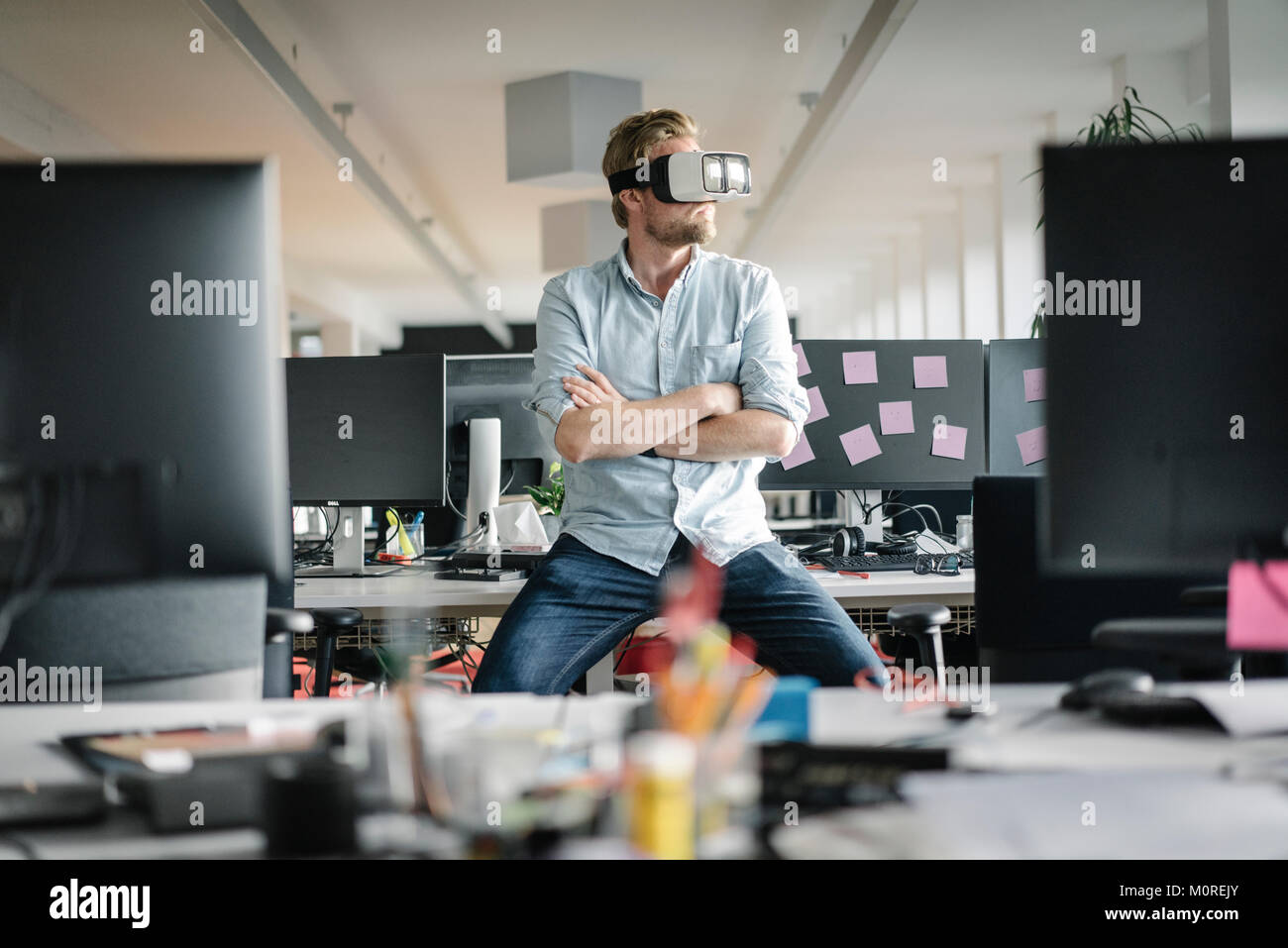 Businessman wearing VR glasses in office Stock Photo - Alamy