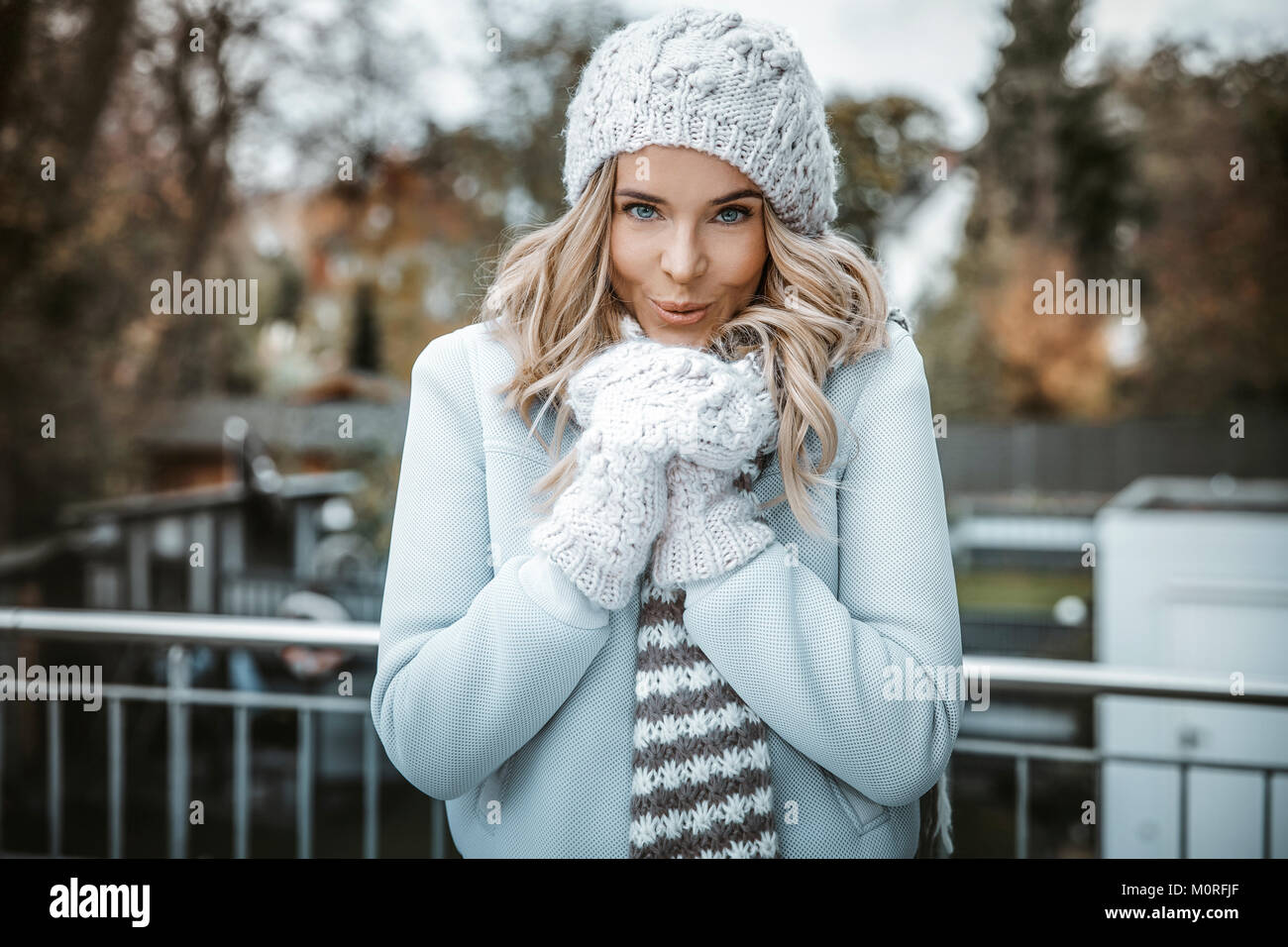 Portrait of smiling woman wearing woolly hat, gloves and scarf Stock Photo