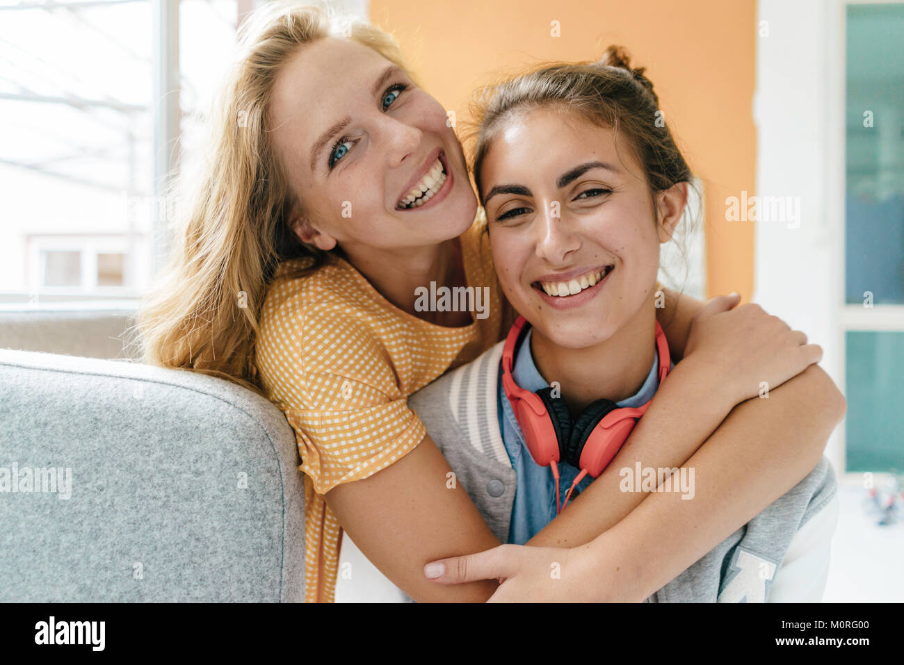 Portrait of two happy young women hugging Stock Photo - Alamy