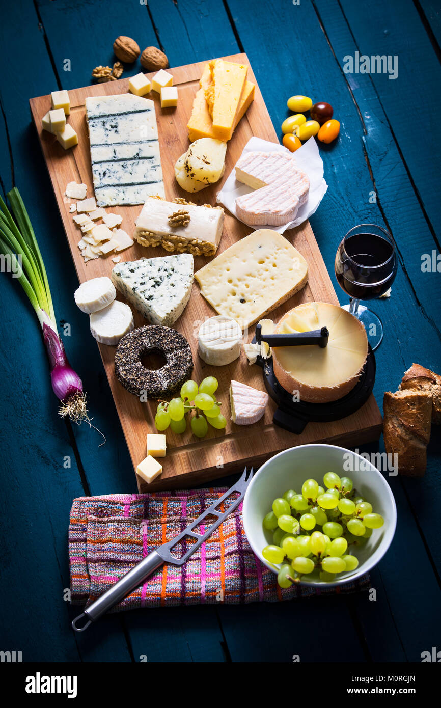 Traditional tete de moine aged mountain cheese of the Alps served with  grapes and walnuts wooden design board with copy space Stock Photo - Alamy