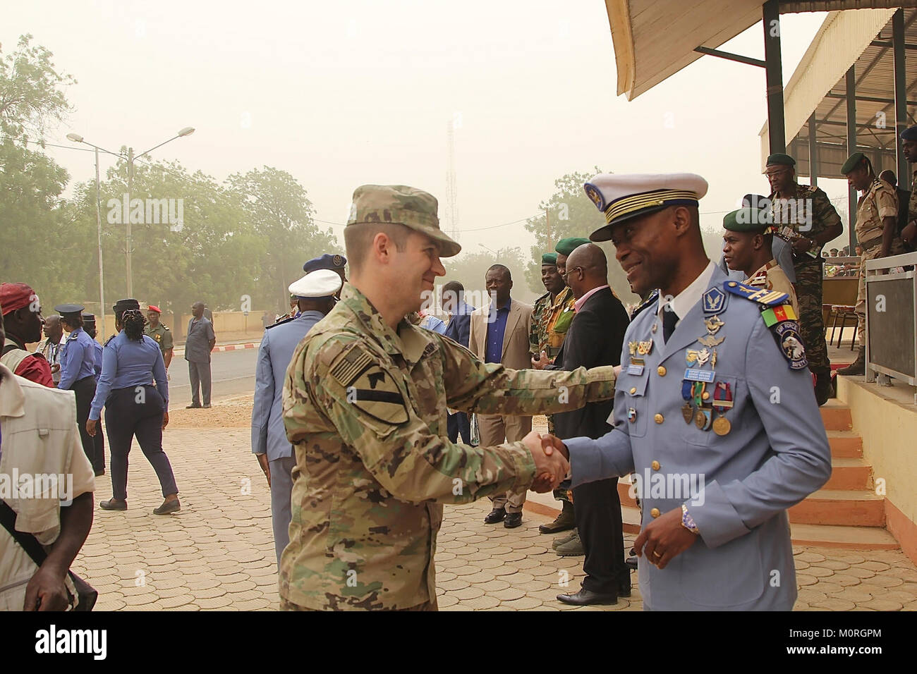 Maj. Andrzej Kujawski, Task Force Darby commander at CL Garoua, congratulates Cameroonian Capt. Patrick Ongong, flying instructor at Cameroon Air Base 301, on his promotion to major, Jan. 1. TF Darby soldiers are serving in a support role for the Cameroon military’s fight against the violent extremist organization Boko Haram. Stock Photo