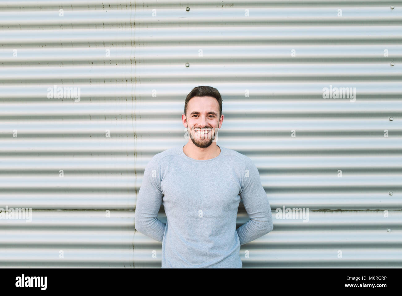 Portrait of laughing man with hands behind his back Stock Photo