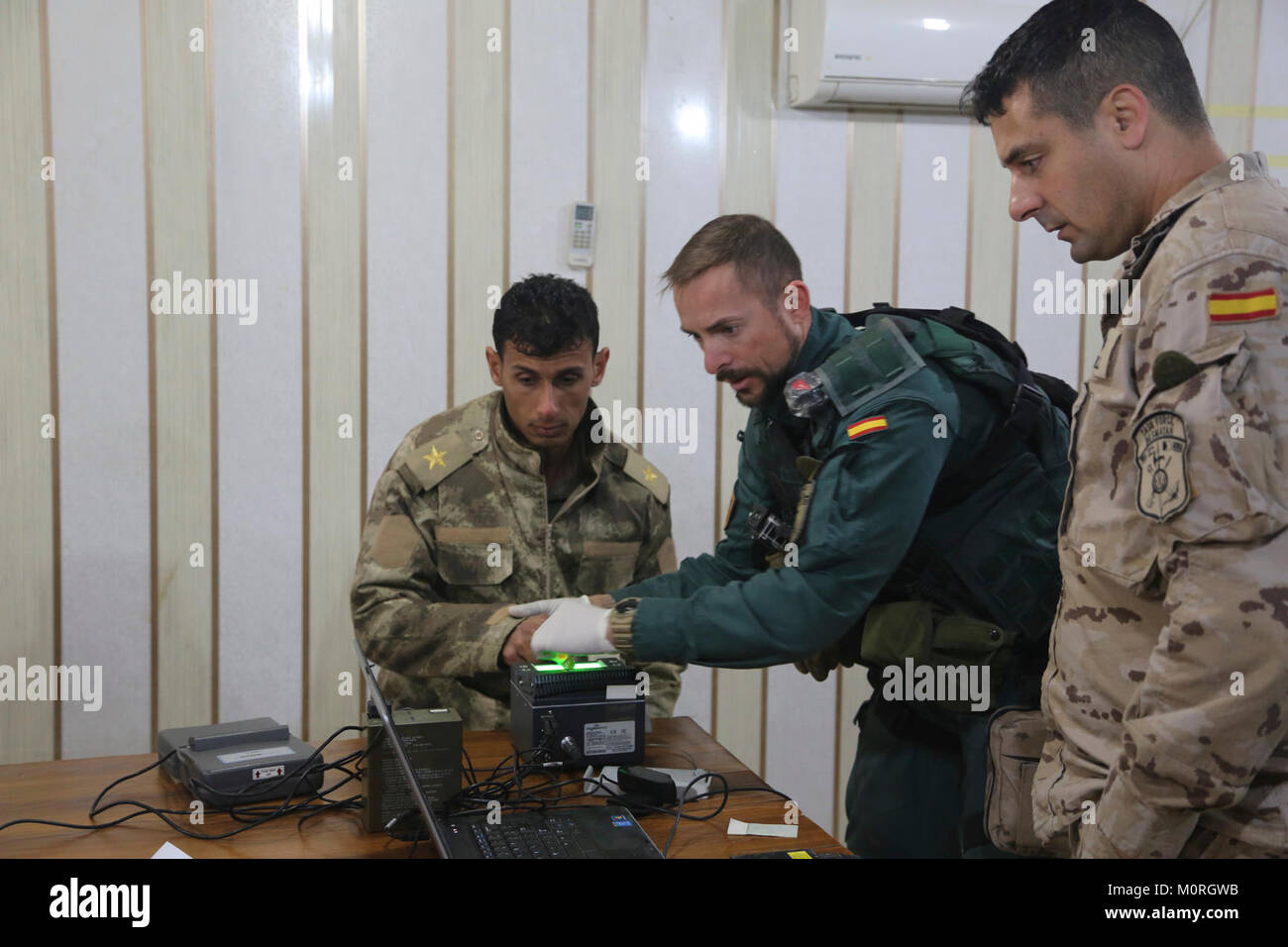 A Spanish Guardia Civil Coalition member takes an Iraqi soldier’s fingerprints to process him into the system during filiation at Camp Besmaya Jan. 3, 2018.  The Coalition enables its partners through the build partner capacity mission to provide security and stability. Combined Joint Task Force - Operation Inherent Resolve is the global Coalition to defeat ISIS in Iraq and Syria.  (U.S. Army Stock Photo