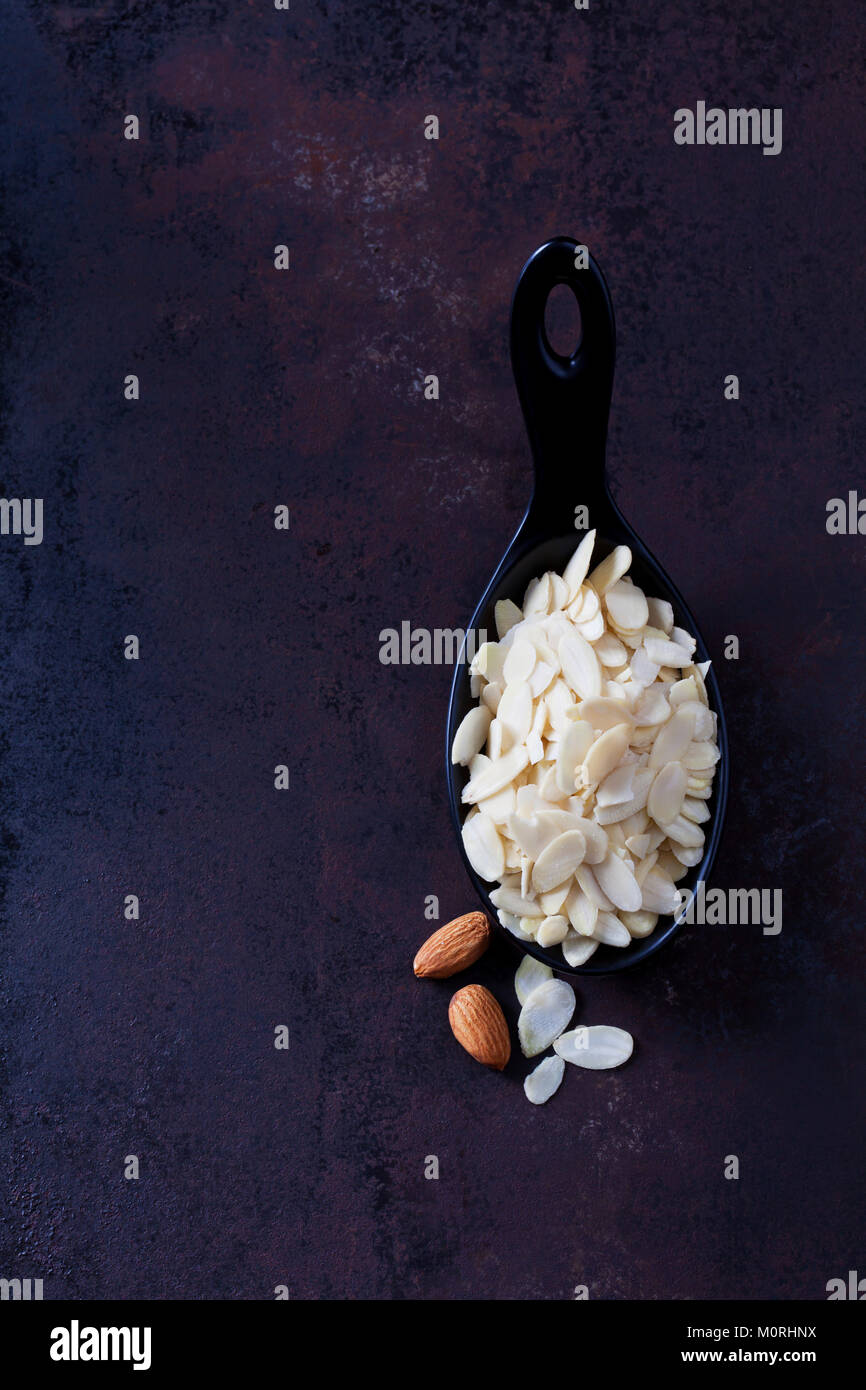 Spoon of sliced and blanched almonds on rusty ground Stock Photo