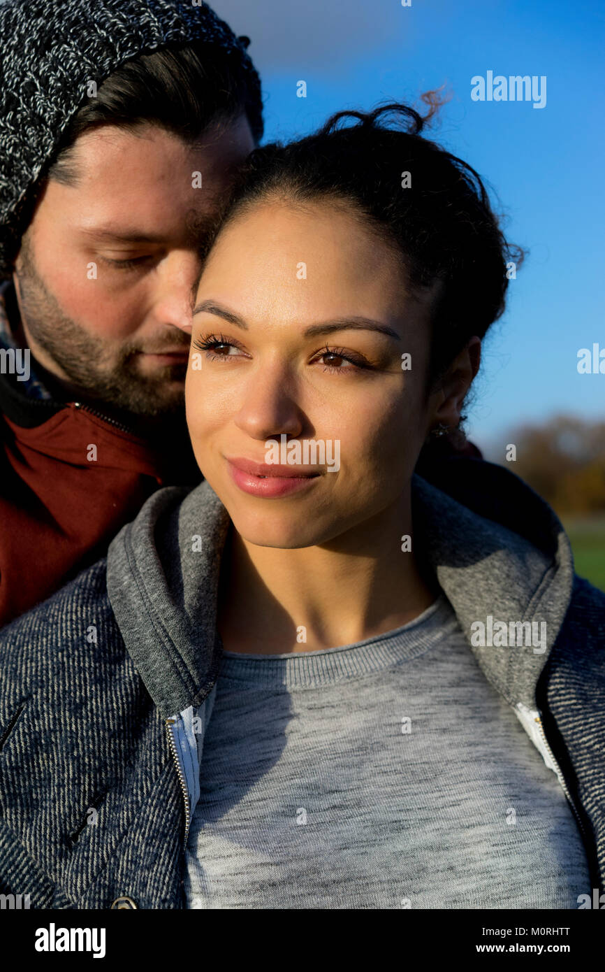 Portrait of smiling young couple close together outdoors Stock Photo ...