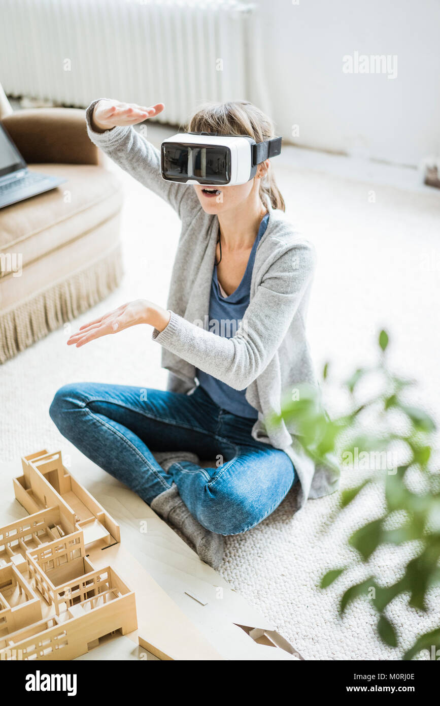 Woman in office with architectural model wearing VR glasses Stock Photo