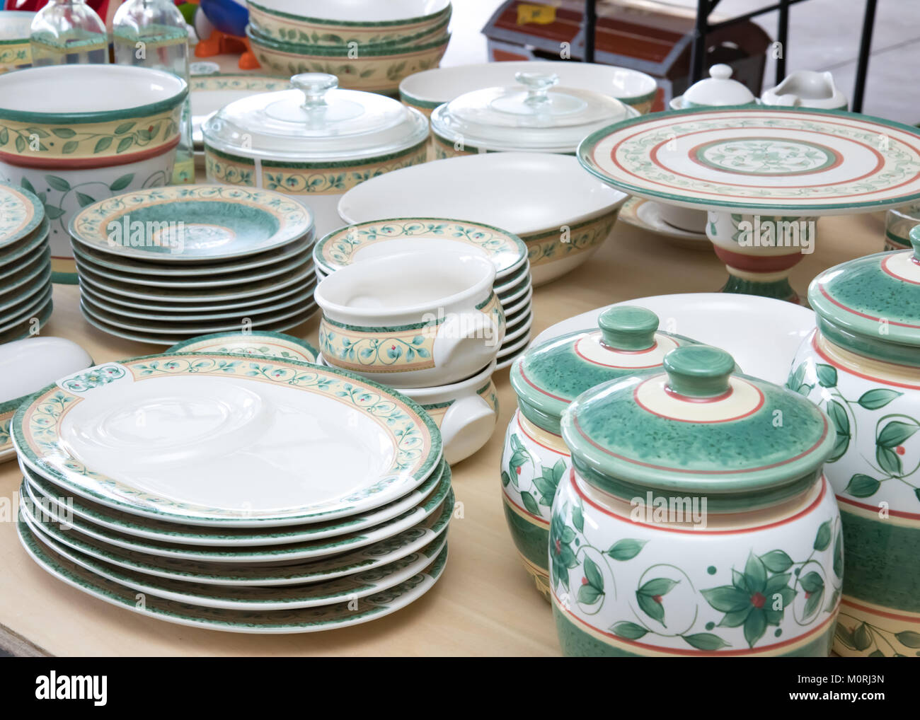 Collection of matching dishes and toys for sale at a garage sale Stock Photo
