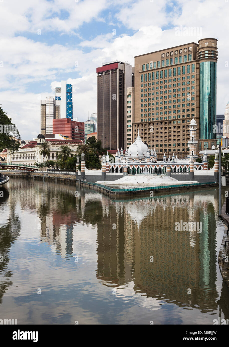 The office buildings reflects in the water of the Klang river, where it meets the Gombak river, in front of the Jamek mosque (masjid) in the heart of  Stock Photo