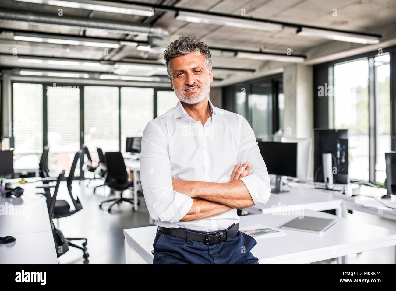 Portrait of smiling mature businessman in office Stock Photo - Alamy
