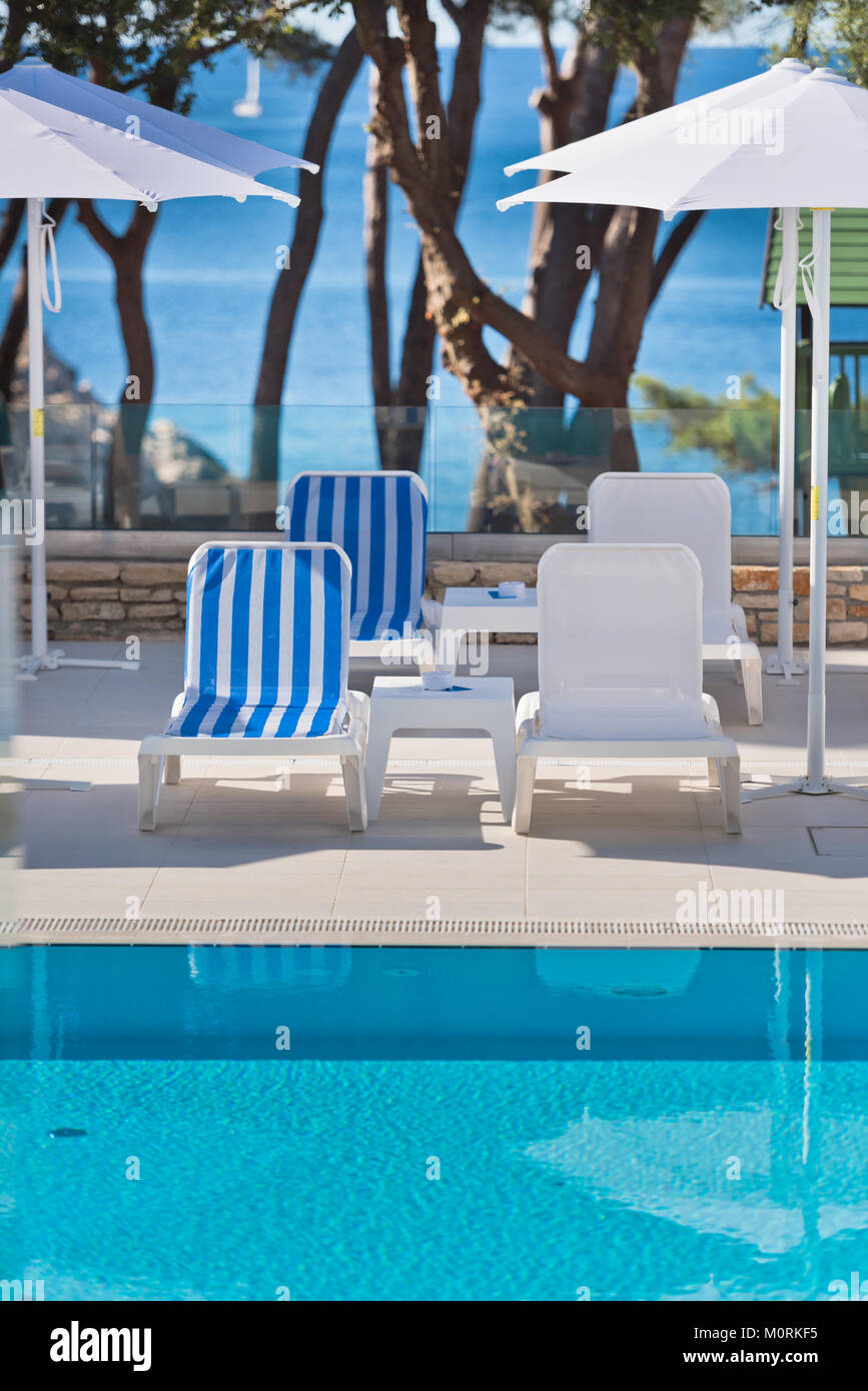 sunbeds and umbrellas by the swimming pool on a sunny day Stock Photo ...