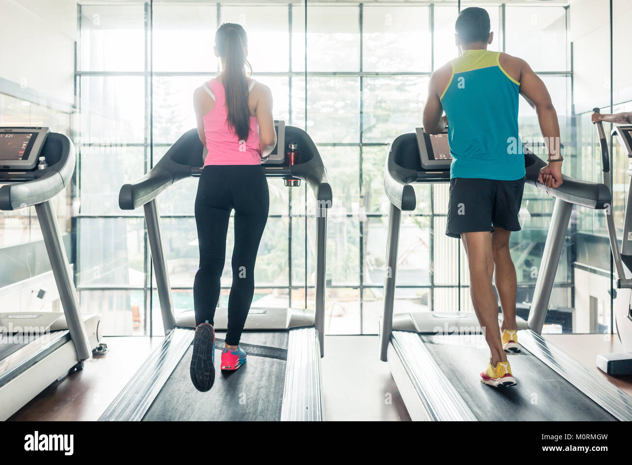 Rear view of a fit woman and her cardio workout partner running Stock ...