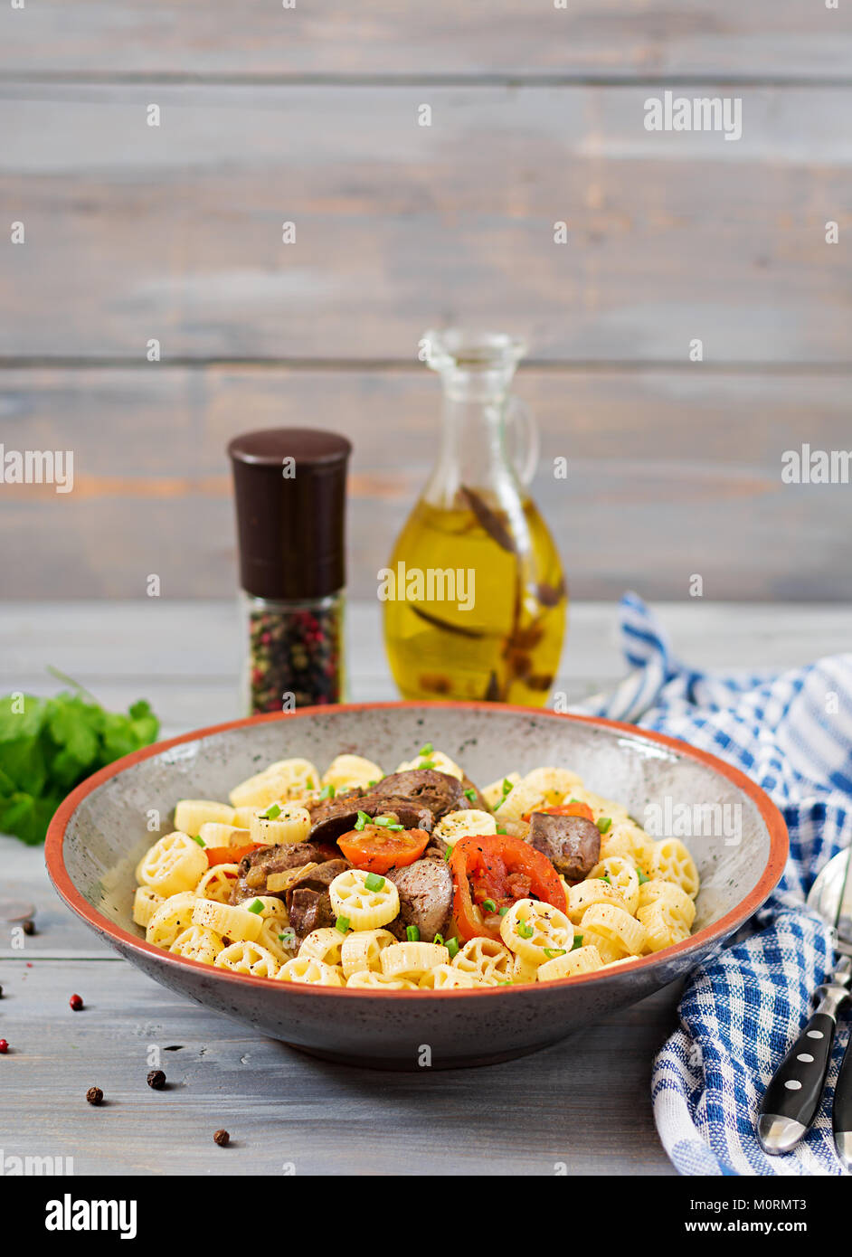Fried chicken liver with tomato and garnish of pasta Stock Photo