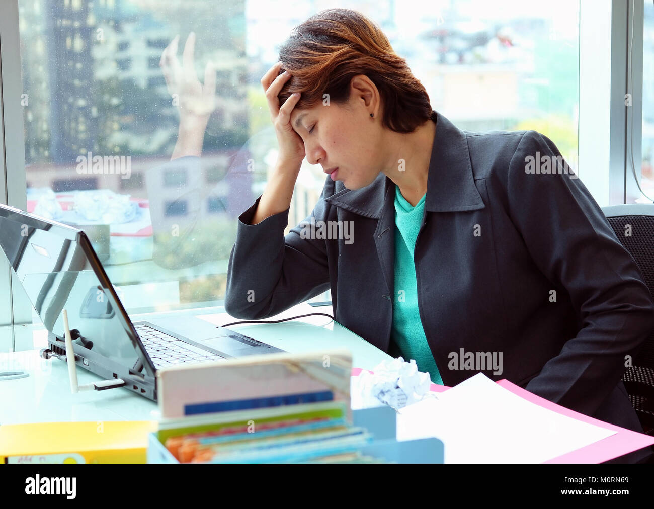 Portrait of tired young business woman with laptop computer in the ...