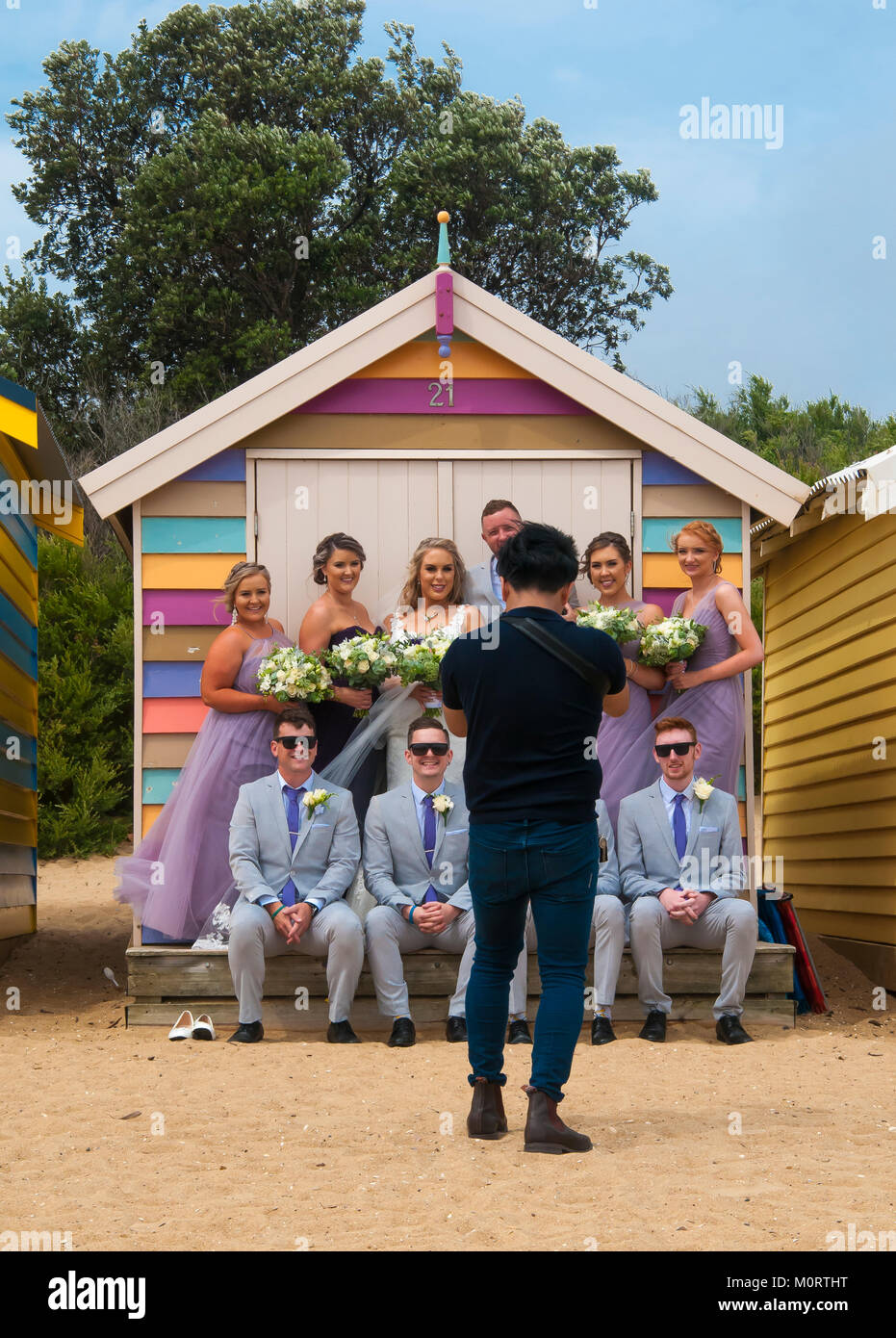 Wedding party posing at the bathing boxes on the Dendy Street Beach at Brighton on Port Phillip Bay, Melbourne, Australia Stock Photo