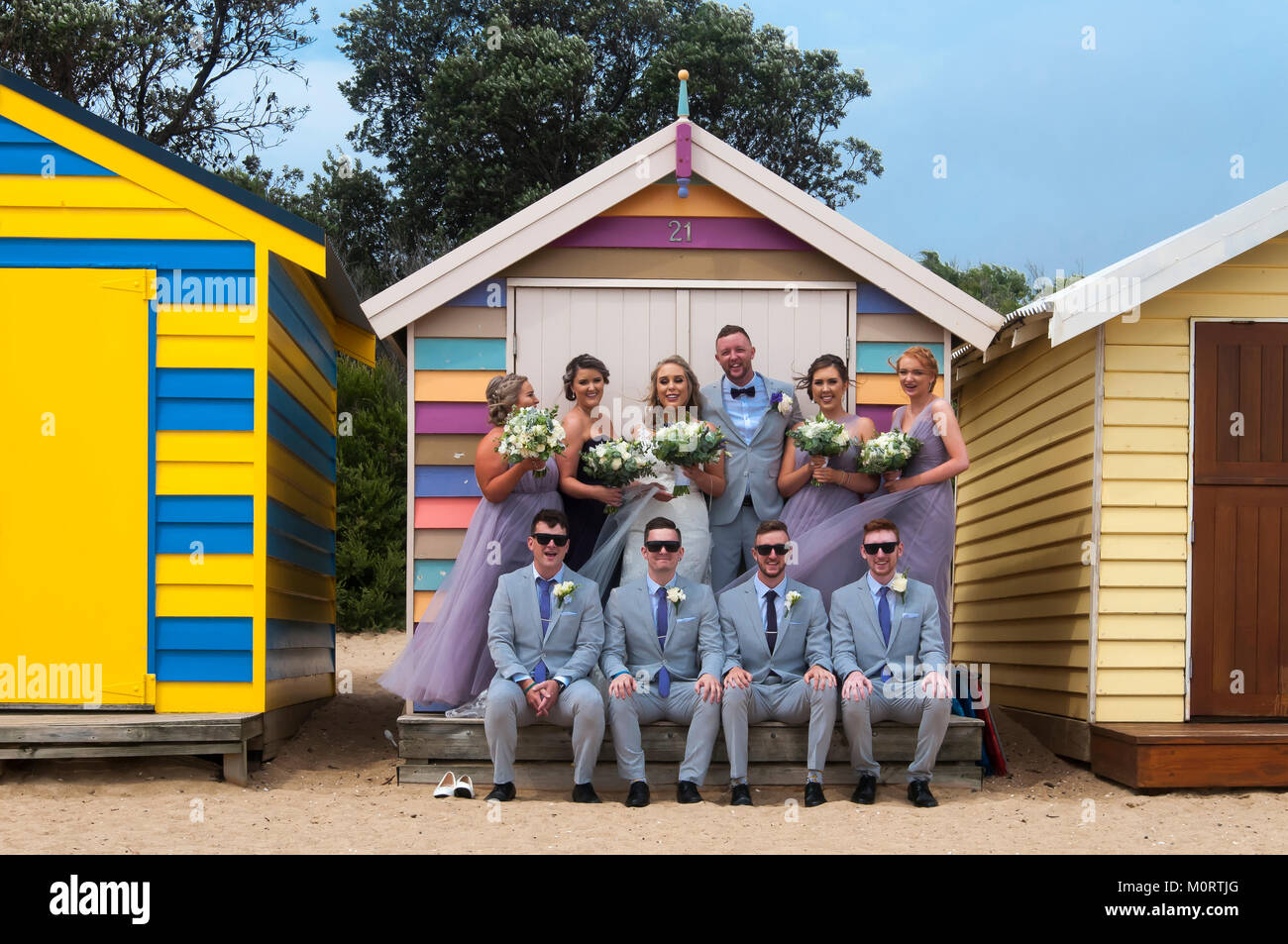 Wedding party posing at the bathing boxes on the Dendy Street Beach at Brighton on Port Phillip Bay, Melbourne, Australia Stock Photo