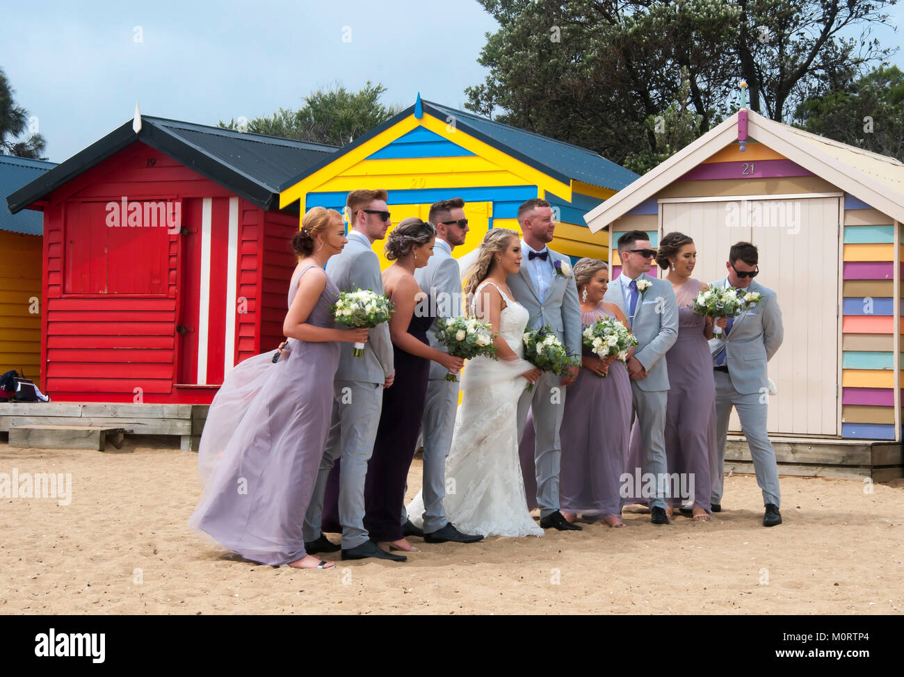 Wedding party posing at the bathing boxes on the Dendy Street Beach at Brighton on Port Phillip Bay, Melbourne, Australia Stock Photo