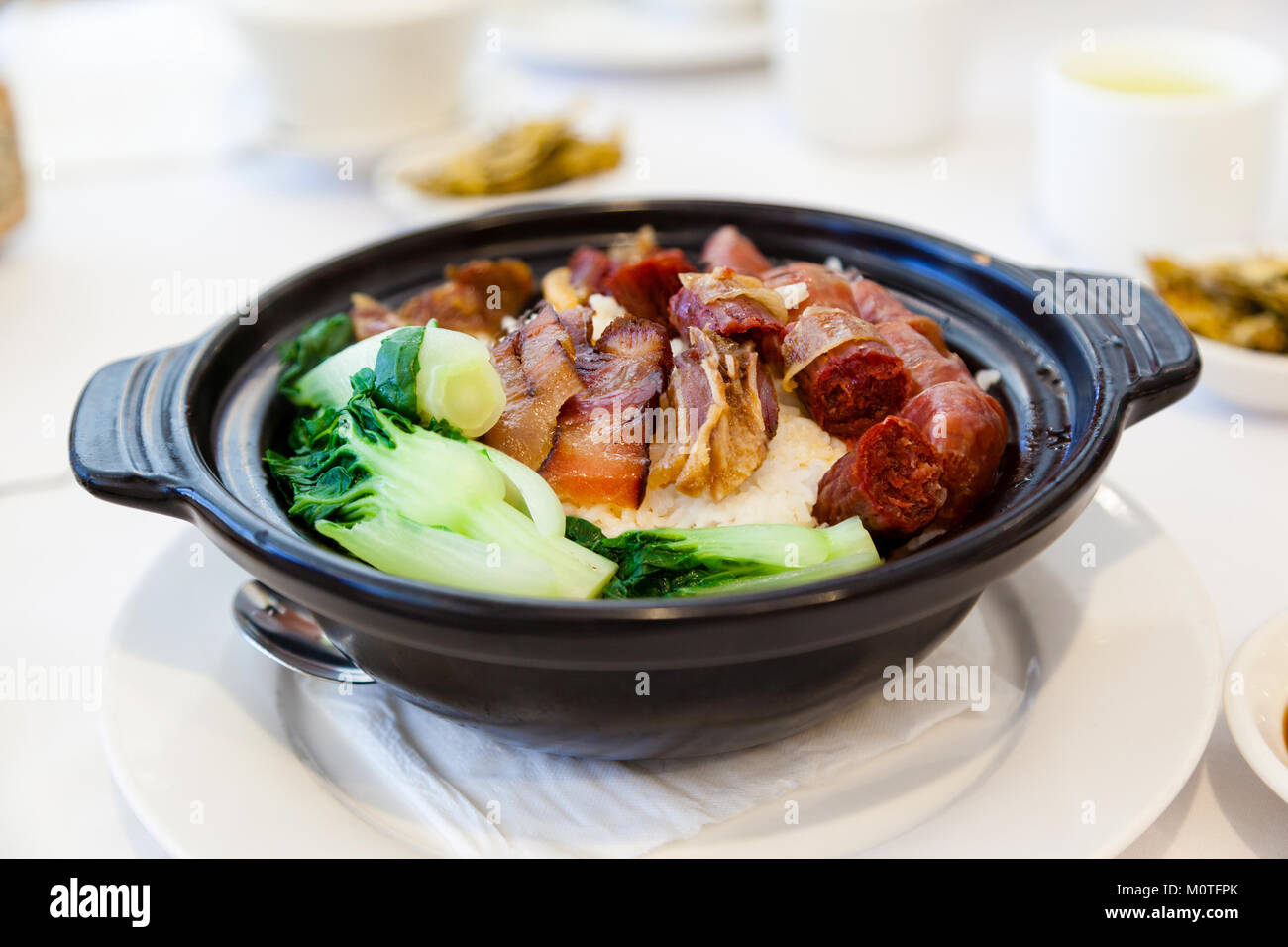 Chinese steamed pork and liver sausages with vegetables and rice in claypot is a popular dish in Cantonese dim sum restaurants in Hong Kong and Southe Stock Photo