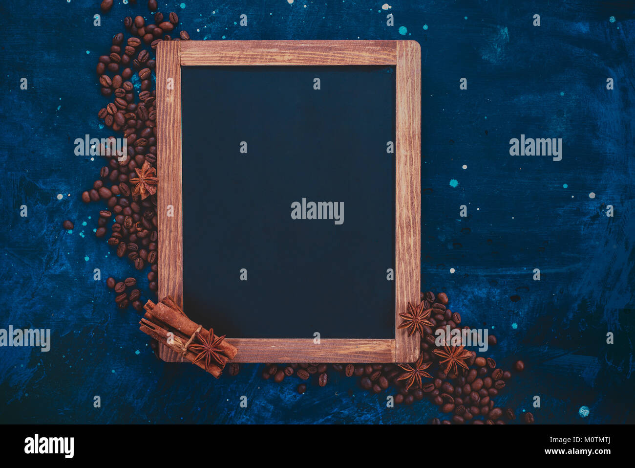 Blackboard frame with coffee beans and spices. Ingredients for making coffee in a creative flat lay concept. Stock Photo