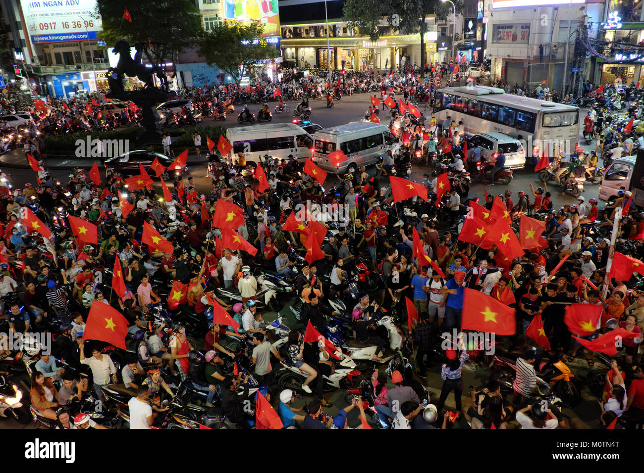 HO CHI MINH CITY, VIET NAM, Crowd of Vietnamese football supporter down the road to celebrate the win after soccer of U23 Vietnam, red flag from fans Stock Photo