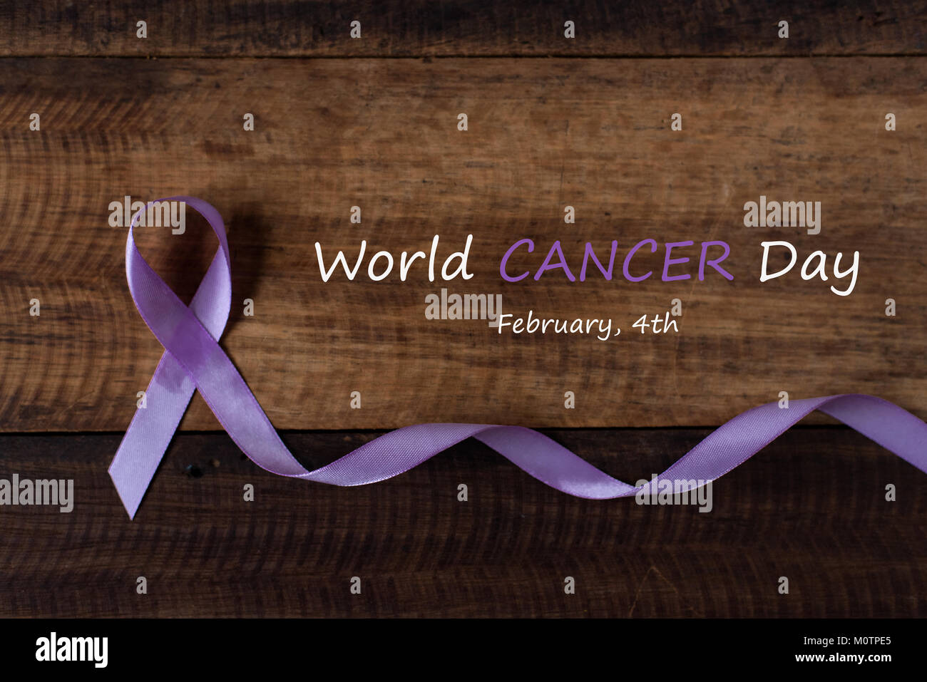 lavender ribbon symbol of all type of cancer on wooden table. world cancer day concept Stock Photo