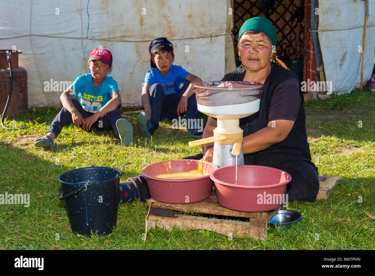 Cream separation process by Kyrgyz woman Song Kol Lake, Naryn province, Kyrgyzstan, Central Asia Stock Photo