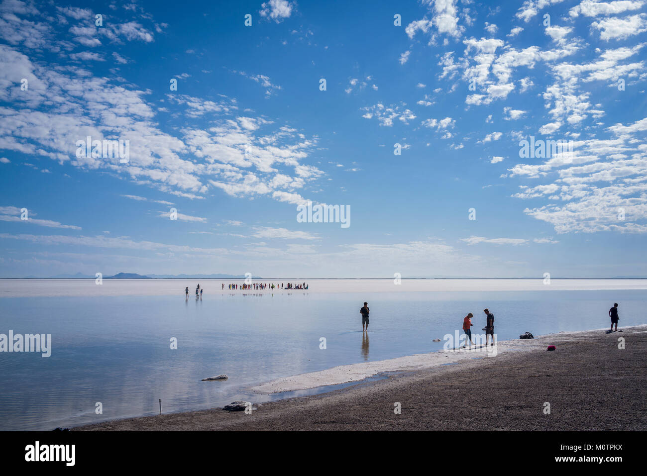 Tourists walk in inches deep salt water near Bonneville Salt Flats, Wendover, Utah Stock Photo