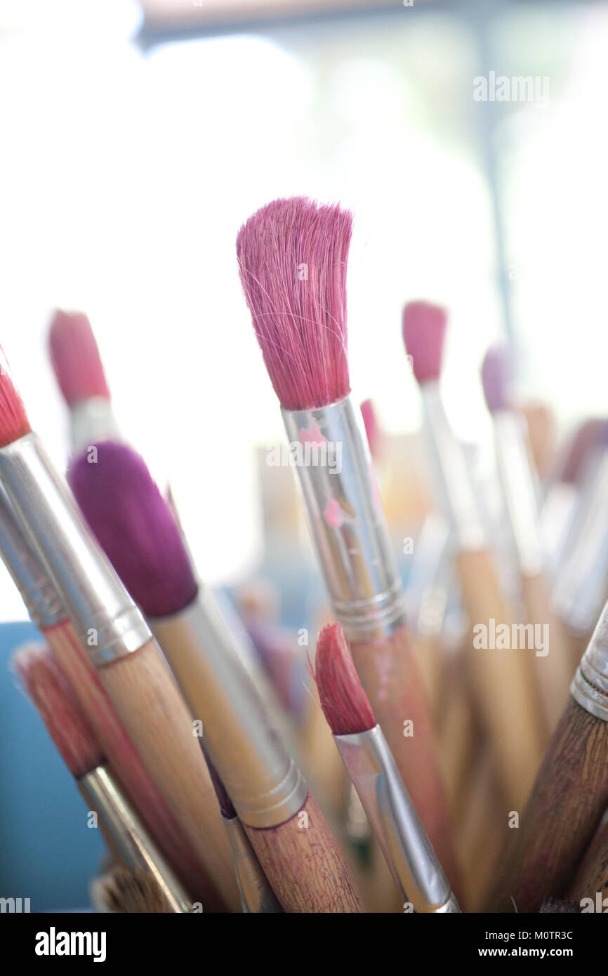Paintbrushes in pots at childcare centre Stock Photo