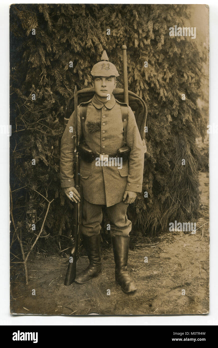 Old German photograph: a handsome young soldier in full gear in military uniform with weapons, a rifle with bayonet knife. The first world war 1914-18 Stock Photo