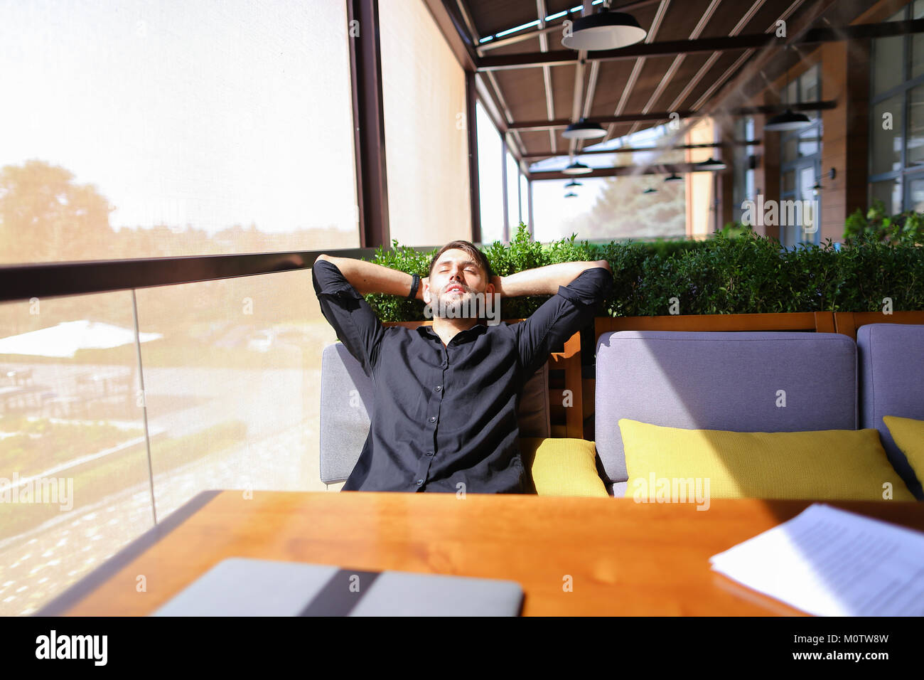 Translator sorting papers and closing laptop lid. Stock Photo