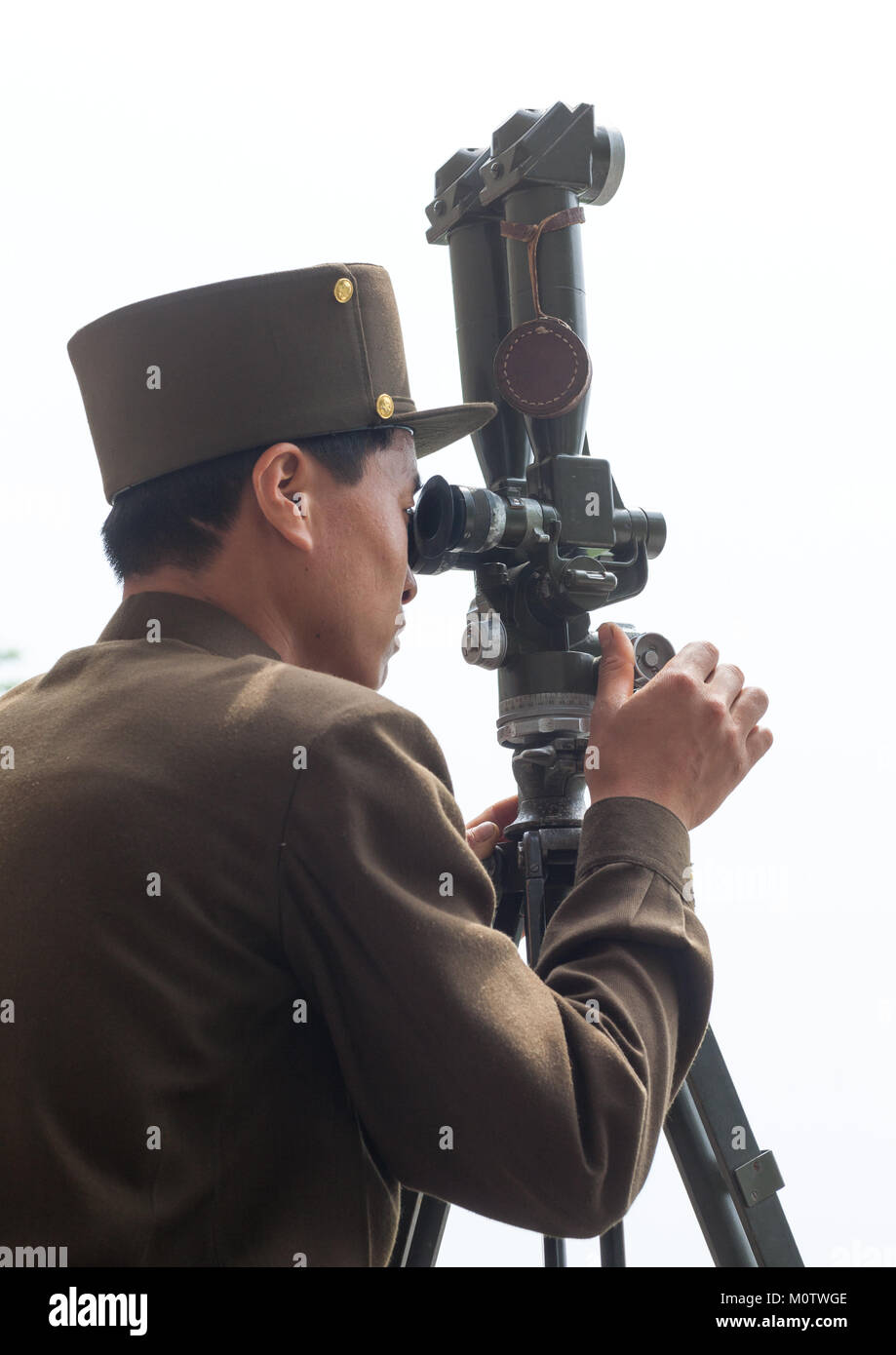 North Korean soldier looking south Korea with binoculars at the