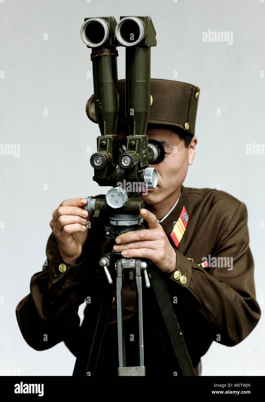 North Korean soldier looking south Korea with binoculars at the