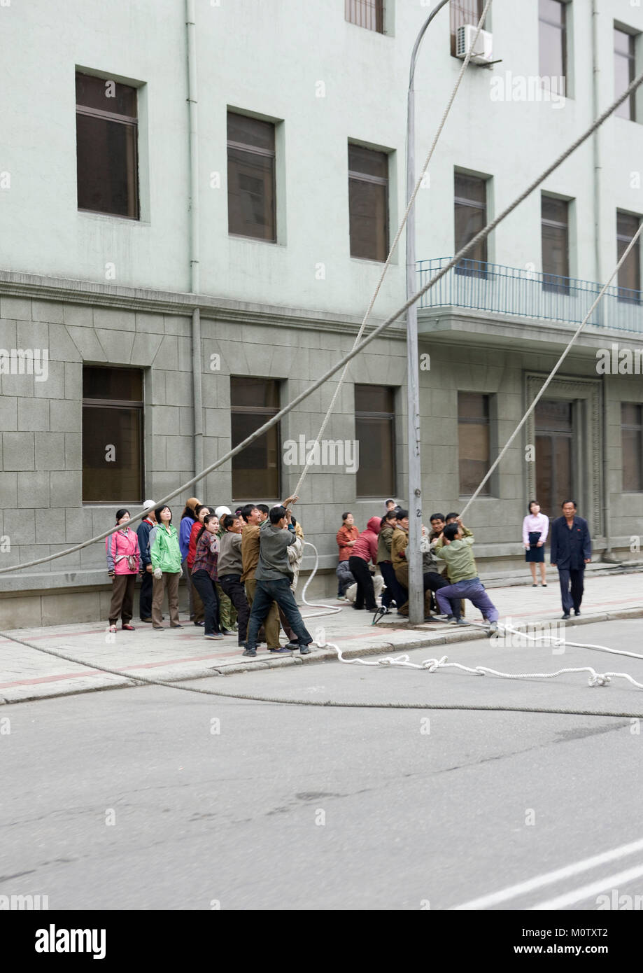 North Korean people pulling on ropes in the street, Pyongan Province