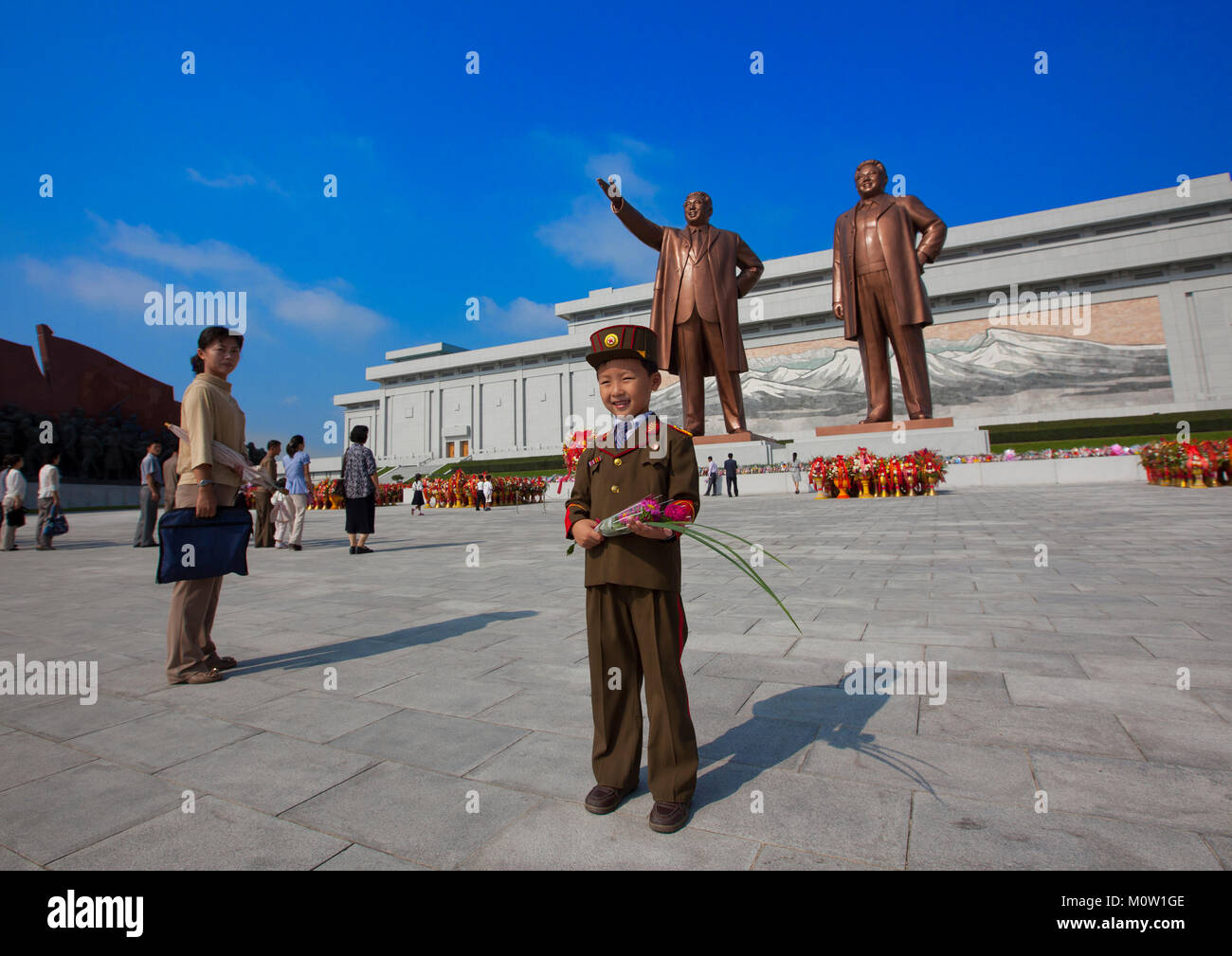 North Korean boy in army uniform paying respect to the two statues of the Dear Leaders in Grand monument of Mansu hill, Pyongan Province, Pyongyang, North Korea Stock Photo