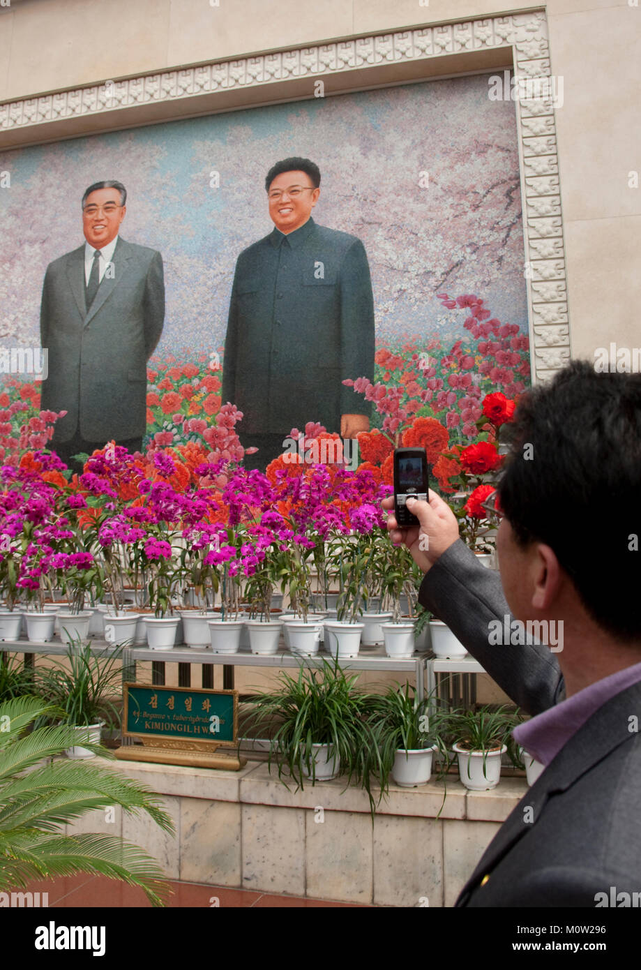 North Korean man taking a picture with his mobile phone at Kimilsungia and Kimjongilia exhibition, Pyongan Province, Pyongyang, North Korea Stock Photo