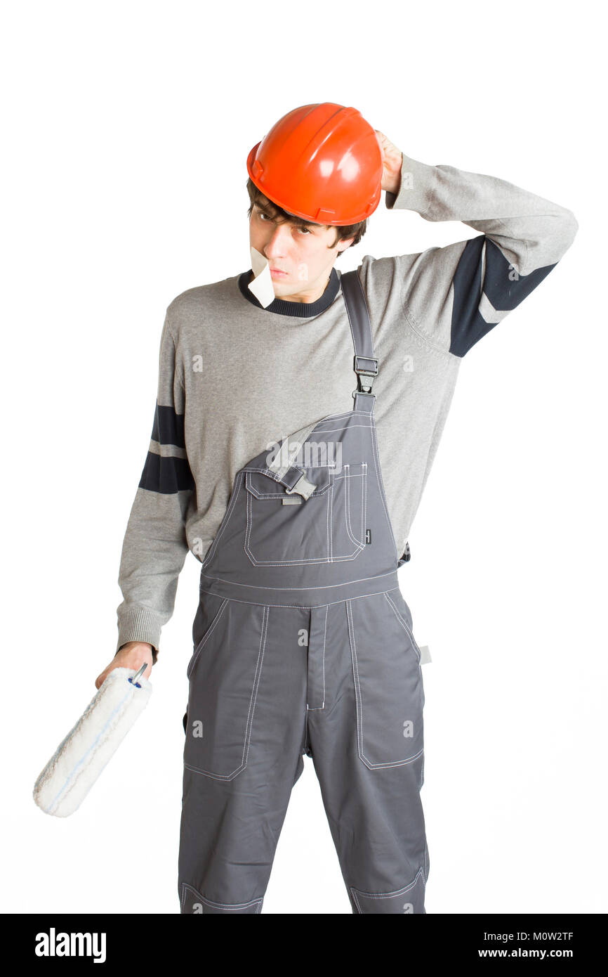 A young man in working grey clothes and orange hard helmet man with tape over mouth. Isolated on white background. Stock Photo